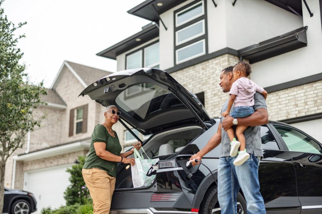 Grandmother and Grandfather Unloading Electric Vehicle